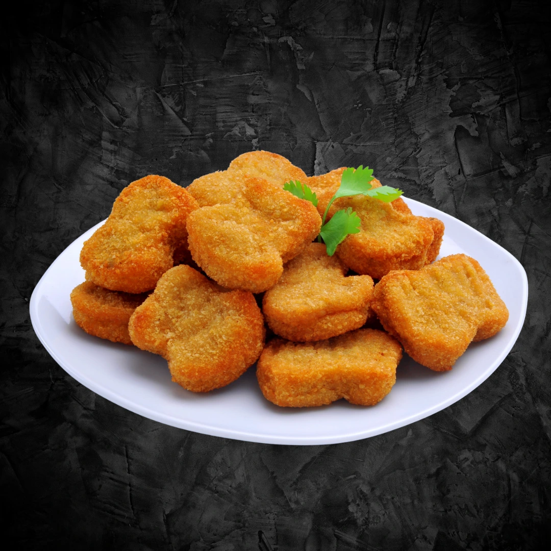 Golden fried chicken nuggets piled on a white plate with coriander garnish on dark background - Seohara Kitchen