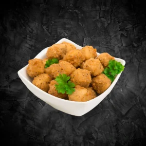 White square bowl filled with golden fried crispy chicken popcorn on a dark background - Seohara Kitchen